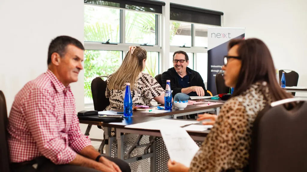 Nexxt Group consultants and a client team working through a planning session around a table of sticky notes